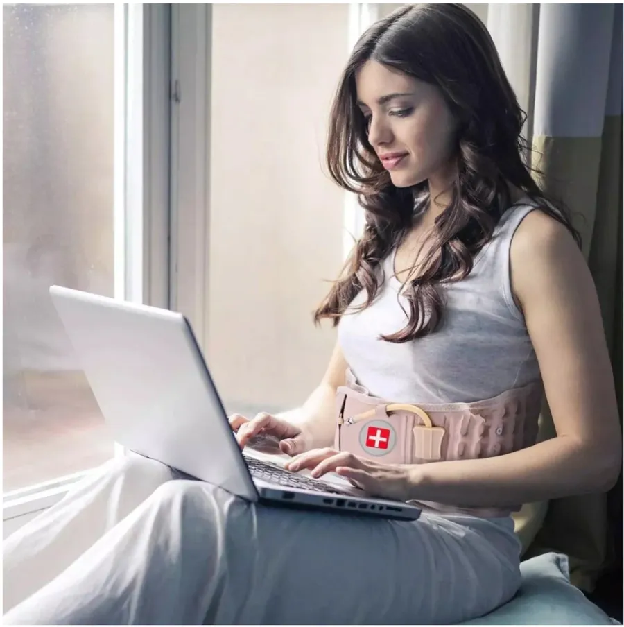Customer wearing the Neurogena decompression therapy belt while working on a laptop.